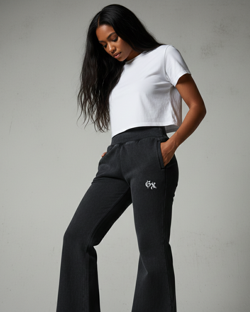 Woman wearing a white t-shirt and black pants with a logo on a gray background